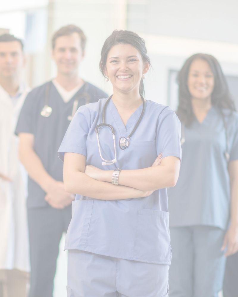 Female doctor with arms crossed in front of a group of healthcare professionals.
