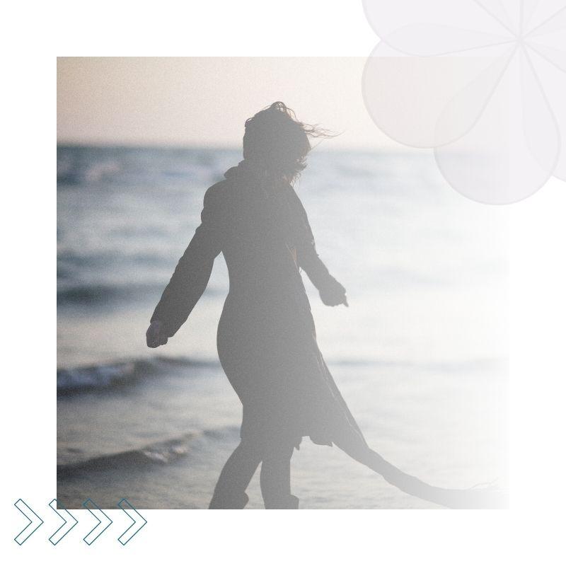 Person walking on a beach with a blurred background
